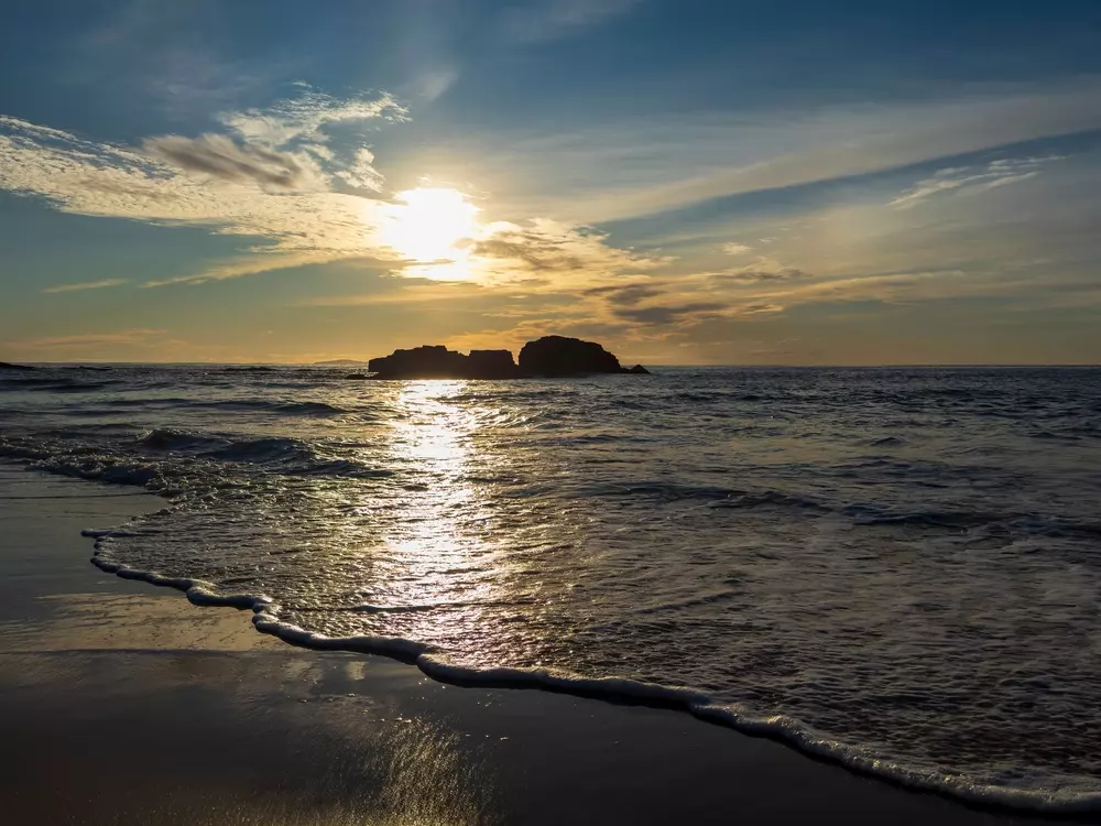 No Mar da Tasmânia é possível ver as rochas de Mystery Bay ao nascer do sol. A luz dourada do sol ilumina as águas. O Mar da Tasmânia é um dos mares inclusos no processo de aquecimento dos oceanos.