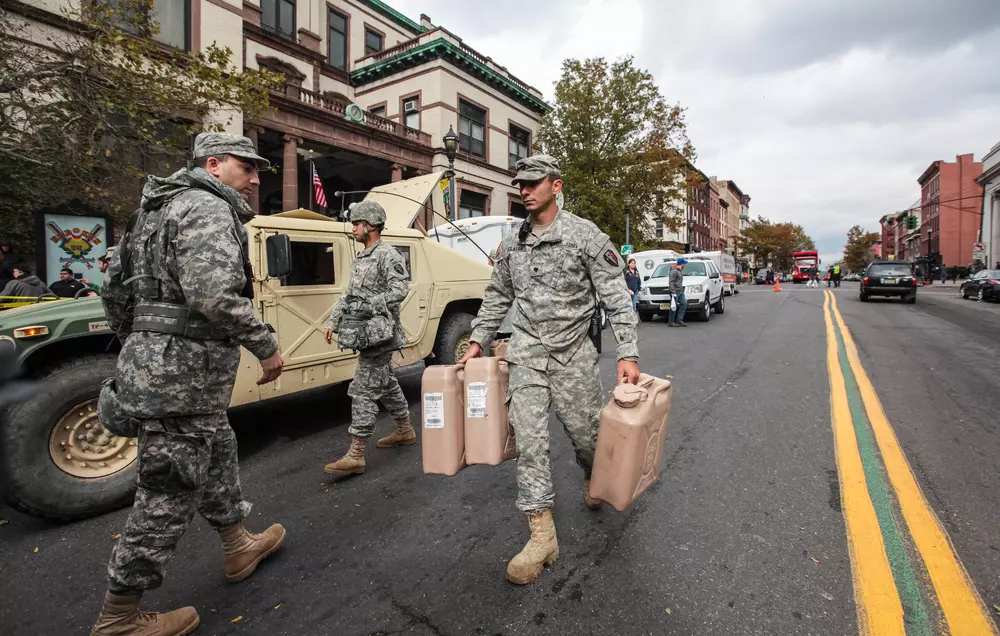 Furacão Sandy em Nova Iorque, com militares ajudando na evacuação e assistência na cidade, destacando o esforço de resgate durante a crise. O projeto The Big U vem como uma das soluções para repensar o urbanismo em áreas costeiras.