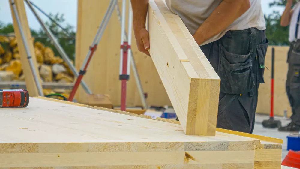 Construção com madeira engenheirada mostrando detalhes de montagem em um ambiente ao ar livre, ideal para projetos de construção sustentável e de alta resistência.