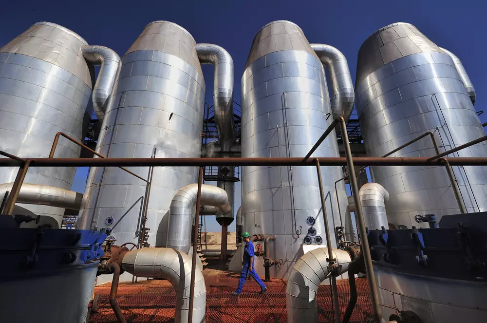 Usina de bioenergia com grandes tanques de armazenamento de energia renovável, destacando processos sustentáveis de geração de energia limpa.